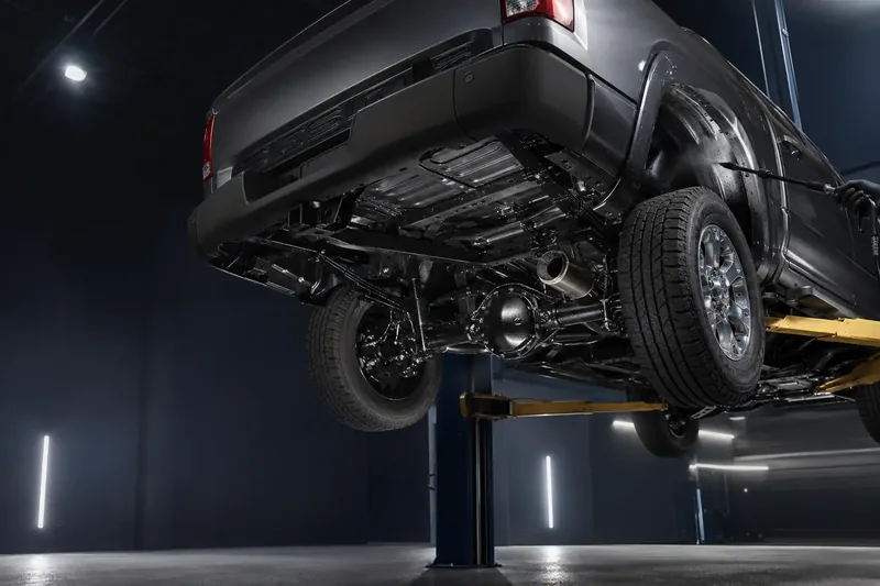 Pickup truck on a lift with its frame protected by black undercoating